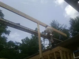 Carpenter setting a ridge beam over a new addition frame — Ice Dam Removal by Roofing Brothers in De Mossville
