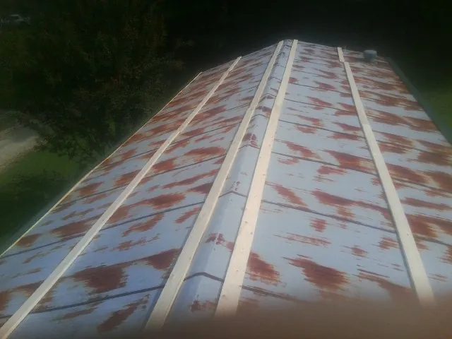 Rusted metal roof panels with new wood purlins before replacement — Storm Damage Roof Repair in De Mossville by Roofing Brothers