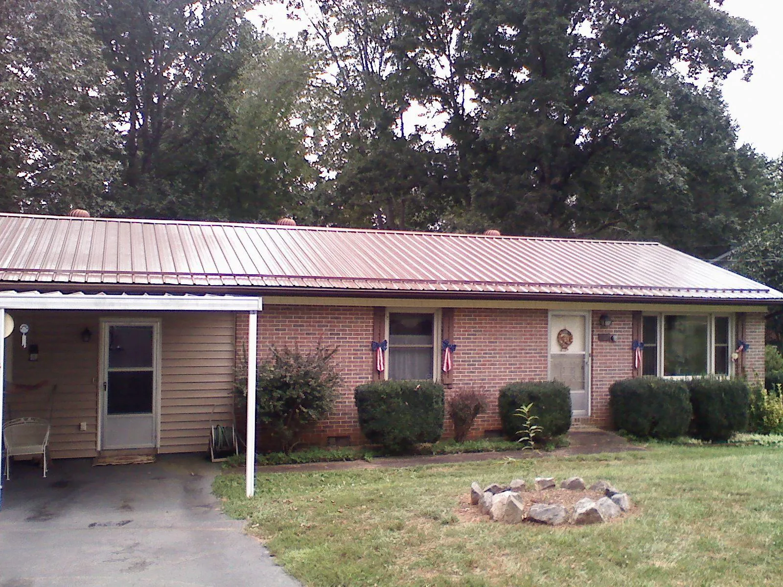 Bronze metal roof and carport on a brick ranch home — Roof Repair work by our crew in De Mossville